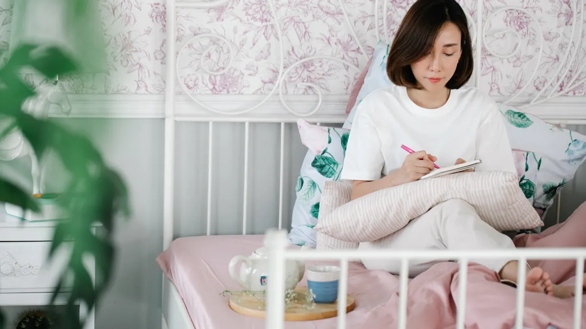 Daily journaling fundamentals — The Complete Guide — A Woman Journaling while Sitting in Bed