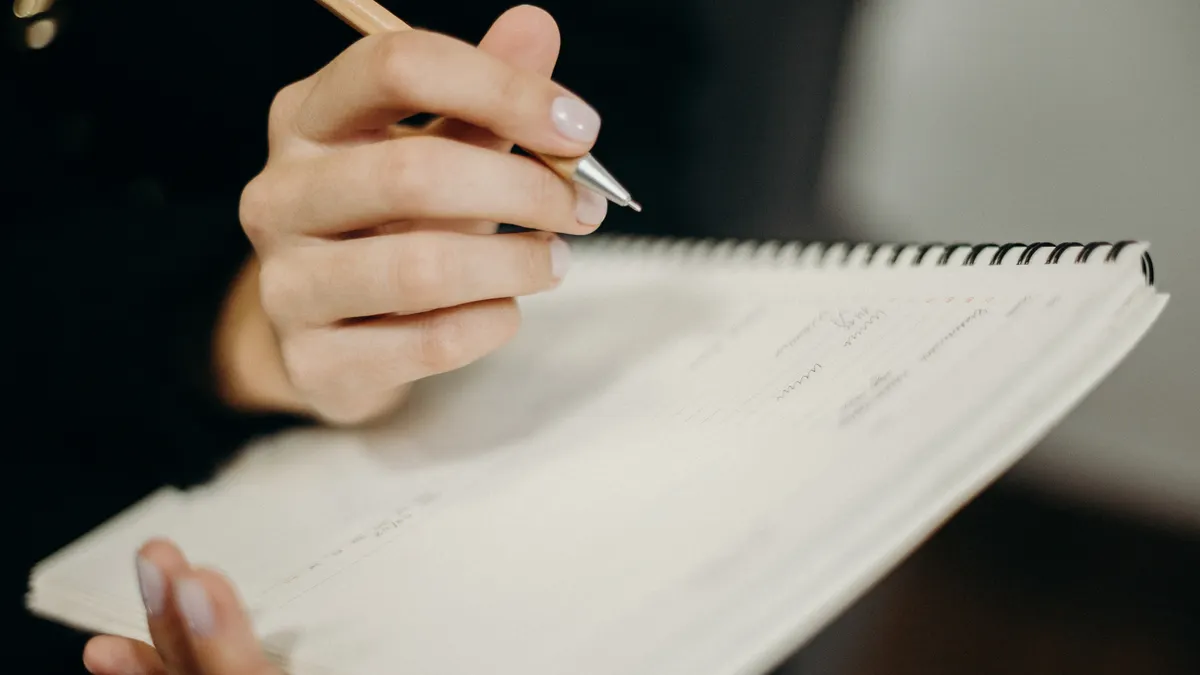 close-up of hand writing in a spiral notebook
