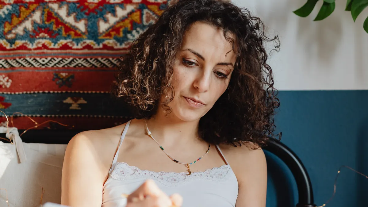 How to journal every day when you have no time — Woman Sitting in Bed and Writing in a Journal