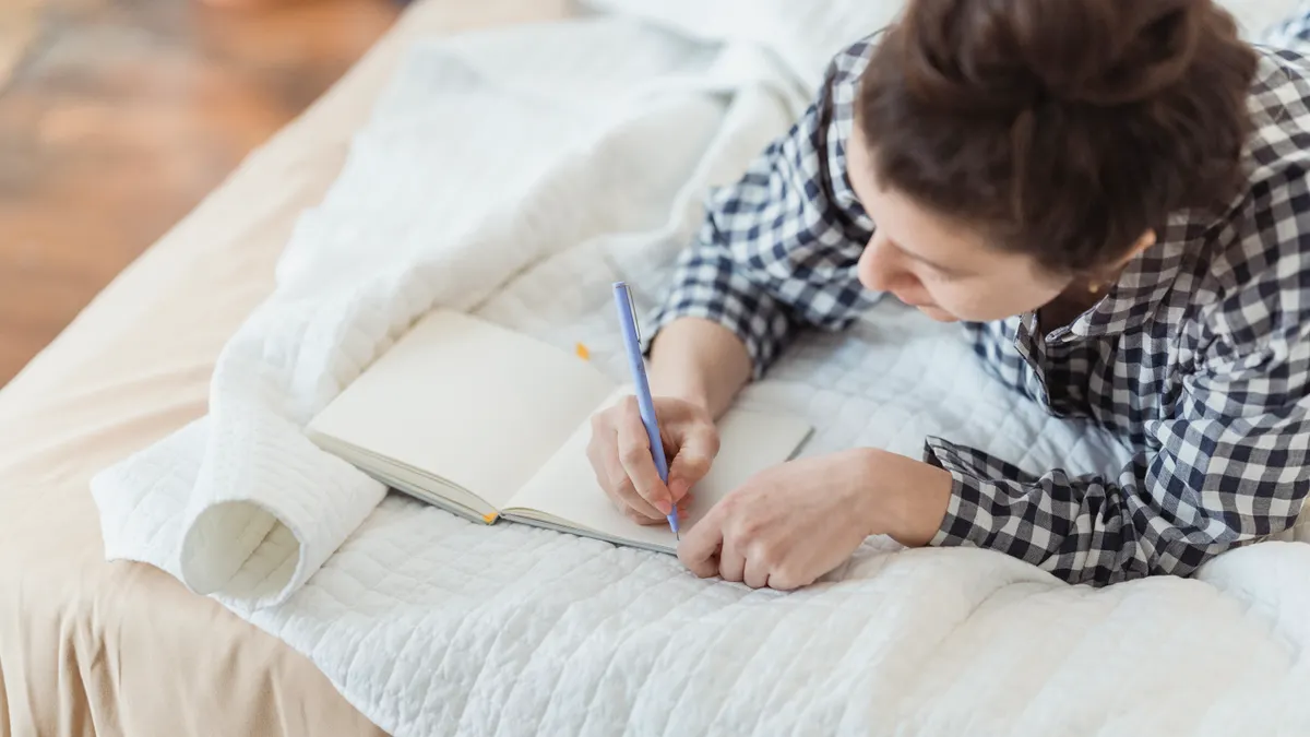 How to use journal prompts without sounding repetitive — Woman Journaling in Bed