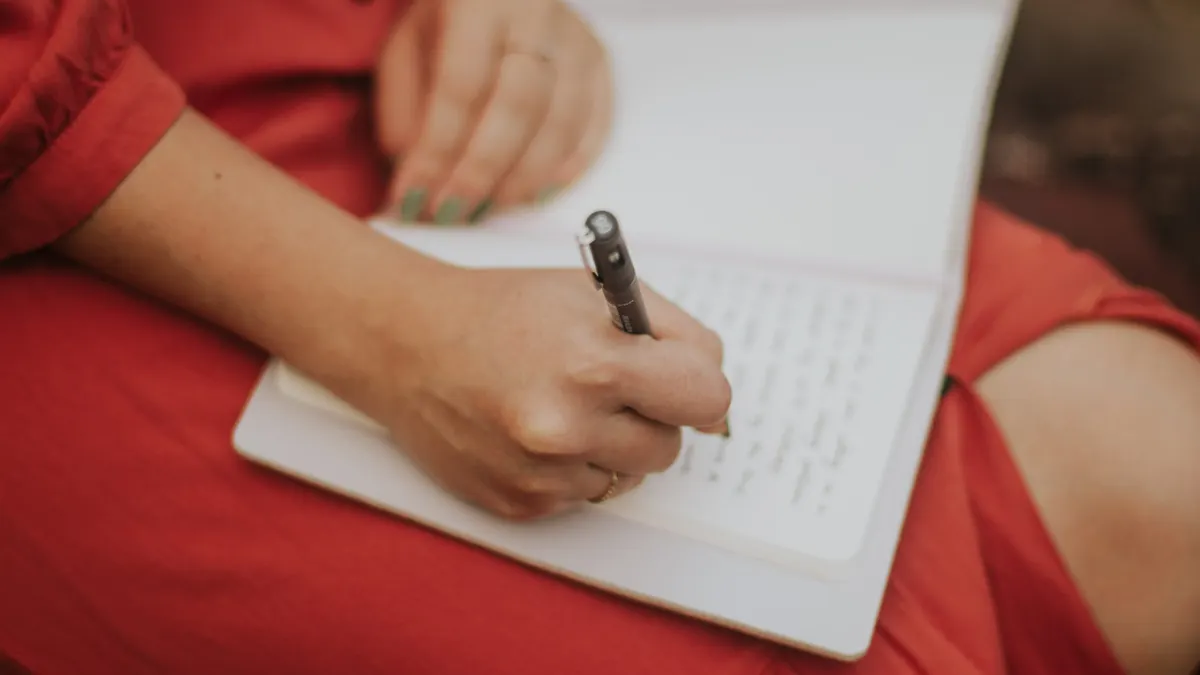 How to use journal prompts without sounding repetitive — Woman Writing in Journal Wearing Red Dress
