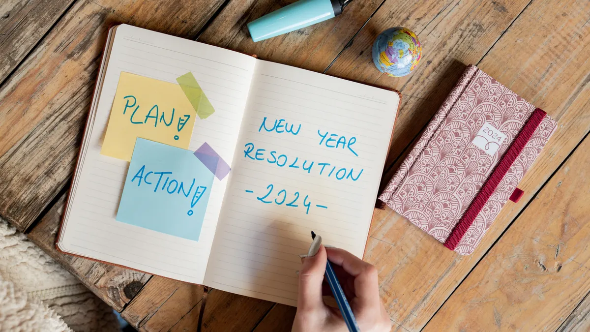 open notebook with plan and action notes and New Year resolution text