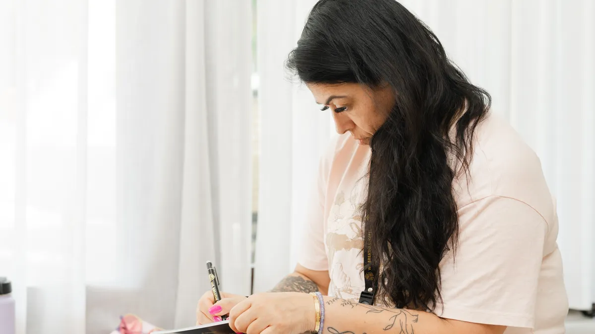Journaling for self-reflection: what to focus on in each entry — Woman Journaling at Relaxing Indoor Retreat